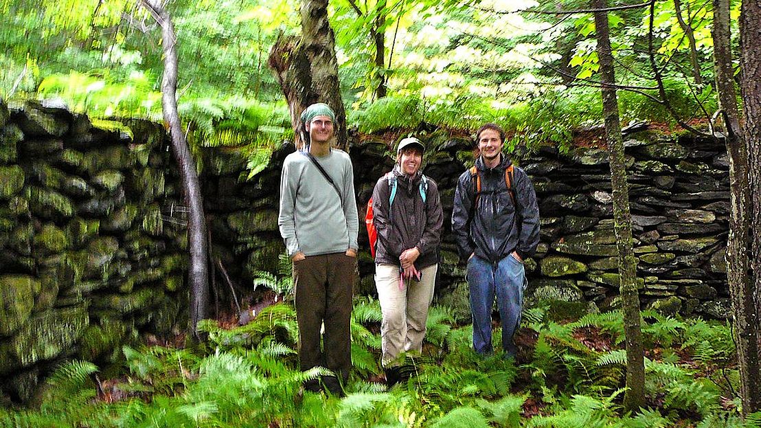 Wolfrun Natural Gateway lands crew in front of stone wall